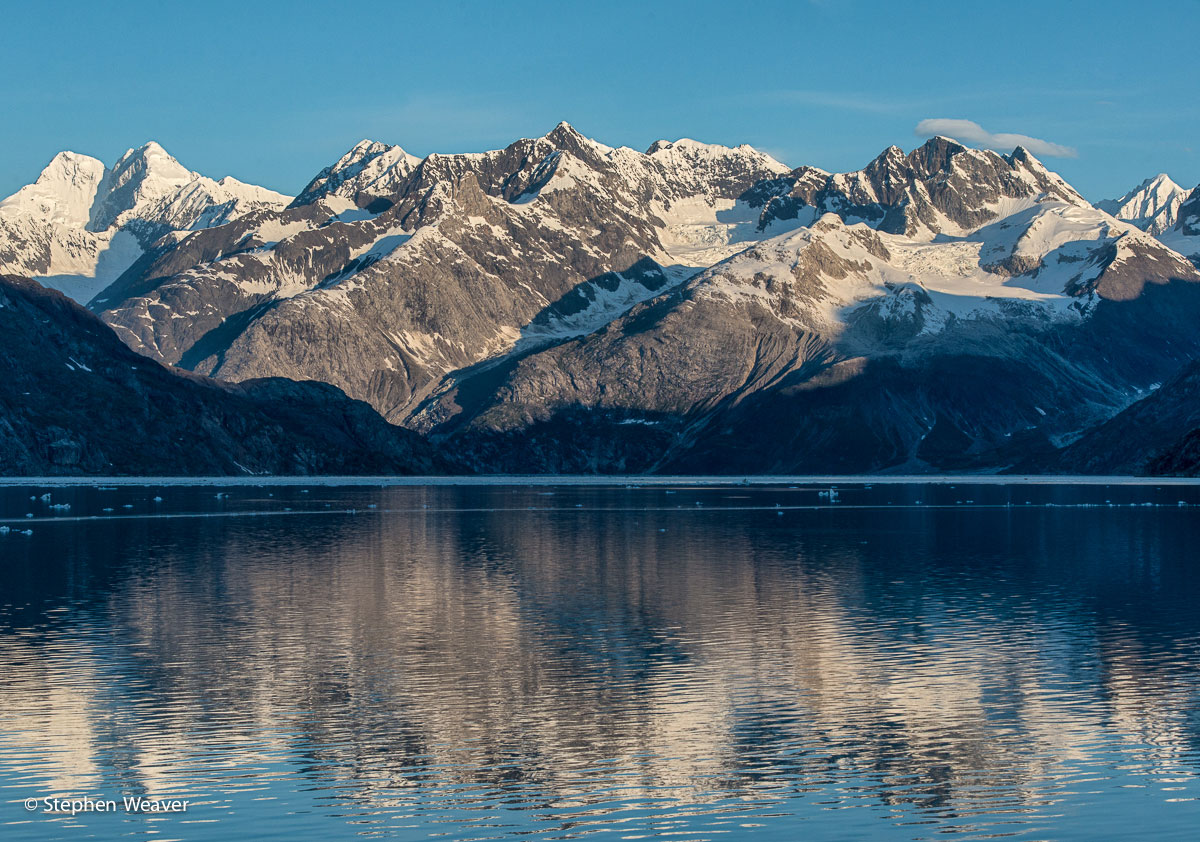 Peaks of the Fairweather Range reflect in the entrance to John Hopkins Inlet in Glacier Bay National Park, Alaska