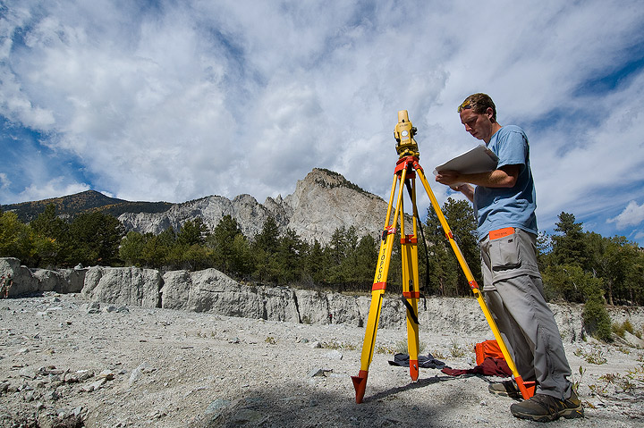 a geology student uses a total station to survey the morphology of a debris flow coming from the Chalk Cliffs on the south side...