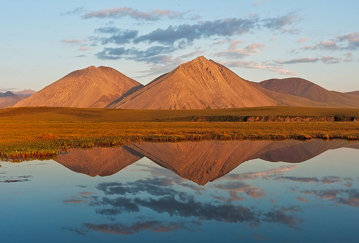 Peaks of the Brooks Range reflect in a small tundra pond near the Canning River in the Arctic National Wildlife Refuge, AK